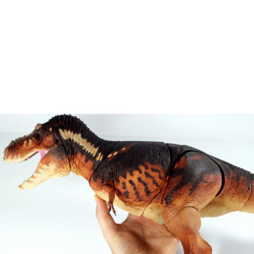 T. rex articulated dinosaur model held in the hand.
